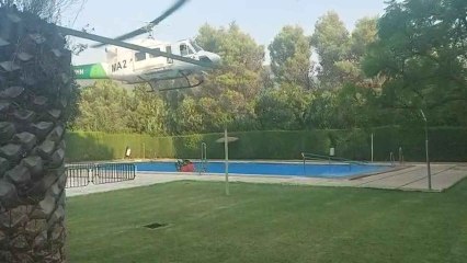 Así carga agua uno de los helicópteros que participan en la extinción del incendio de Sierra Bermeja.