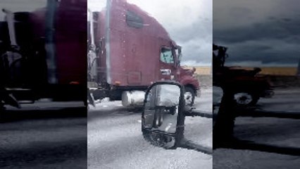 Guy Riding on Side of 18-Wheeler Holding Mirror