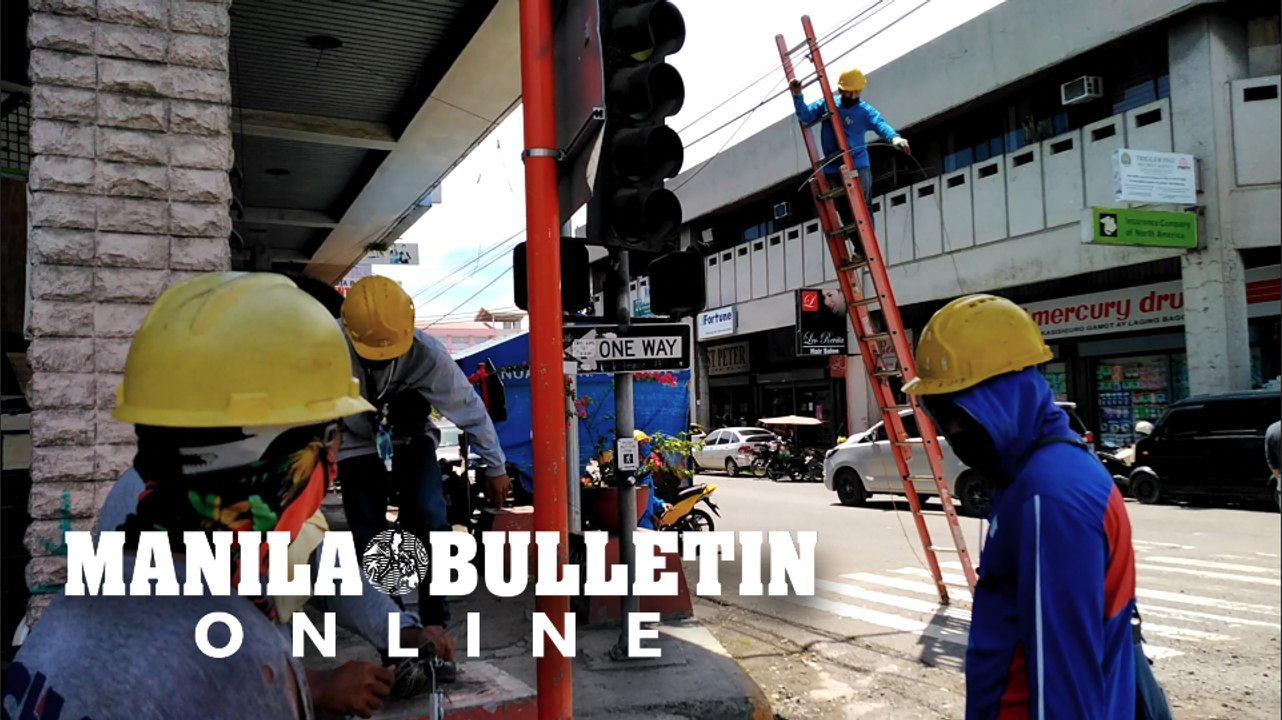 Telco technicians remove cables as part of Davao City's CM Recto street underground cabling project