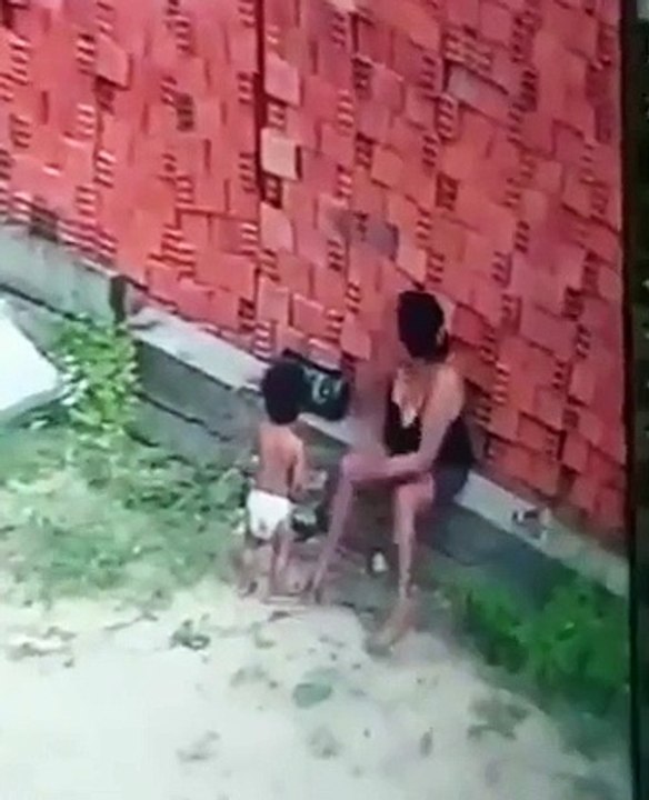 Une maman protège son enfant au moment de la chute d'un mur de briques (Brésil)