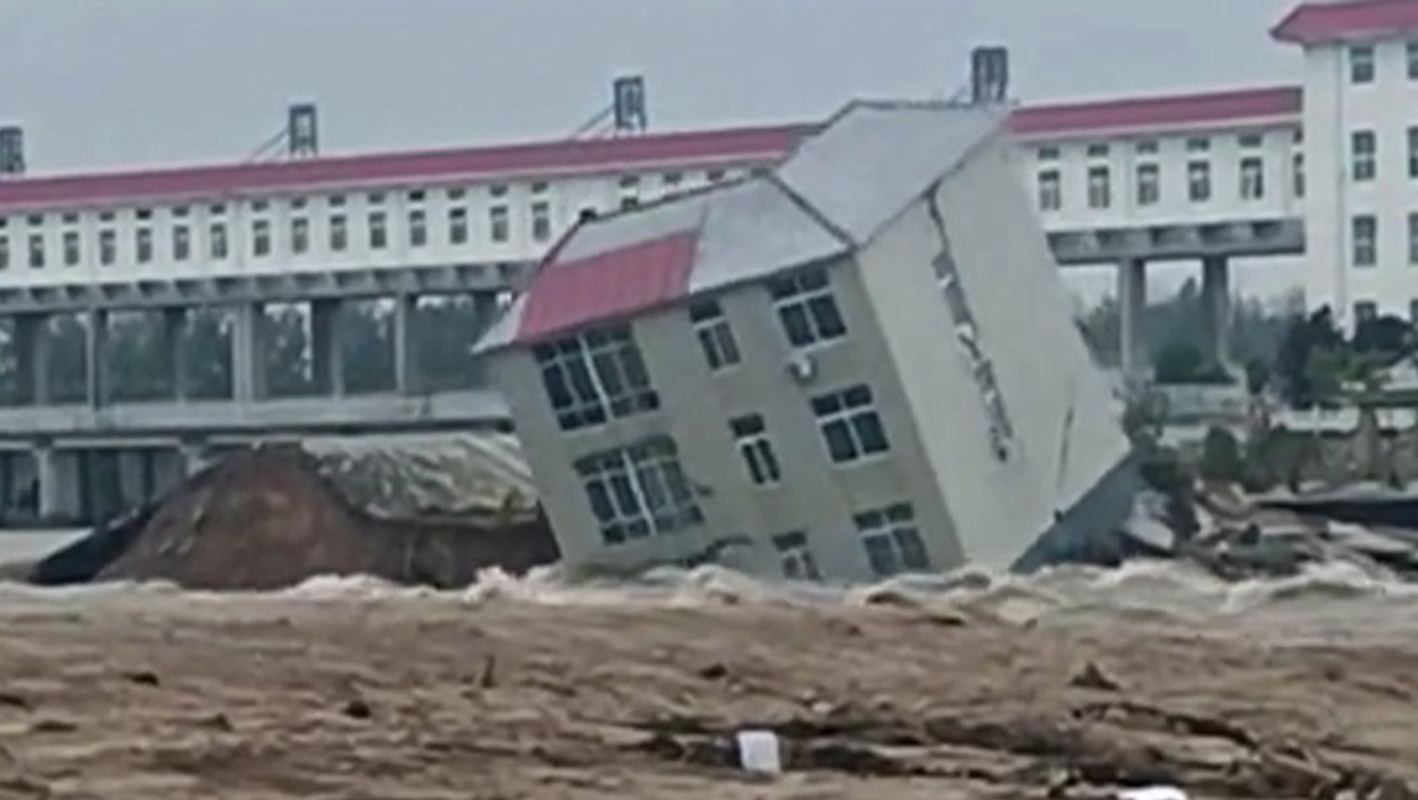 Building collapses into floodwaters in China