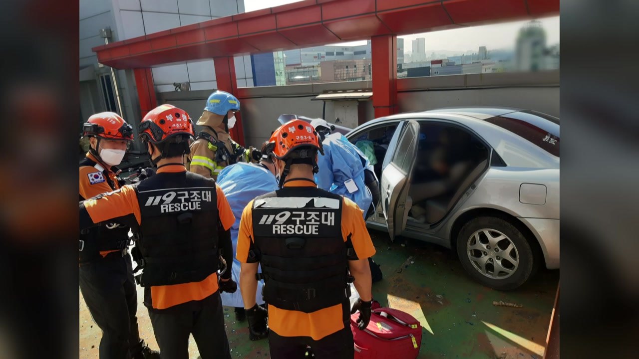 주차타워에서 주차하던 승용차 난간 뚫고 옆 건물 추락...운전자 중상 / YTN
