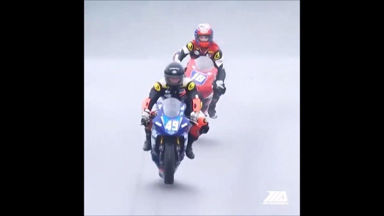 Un pilote de moto chute et double son adversaire en glissade