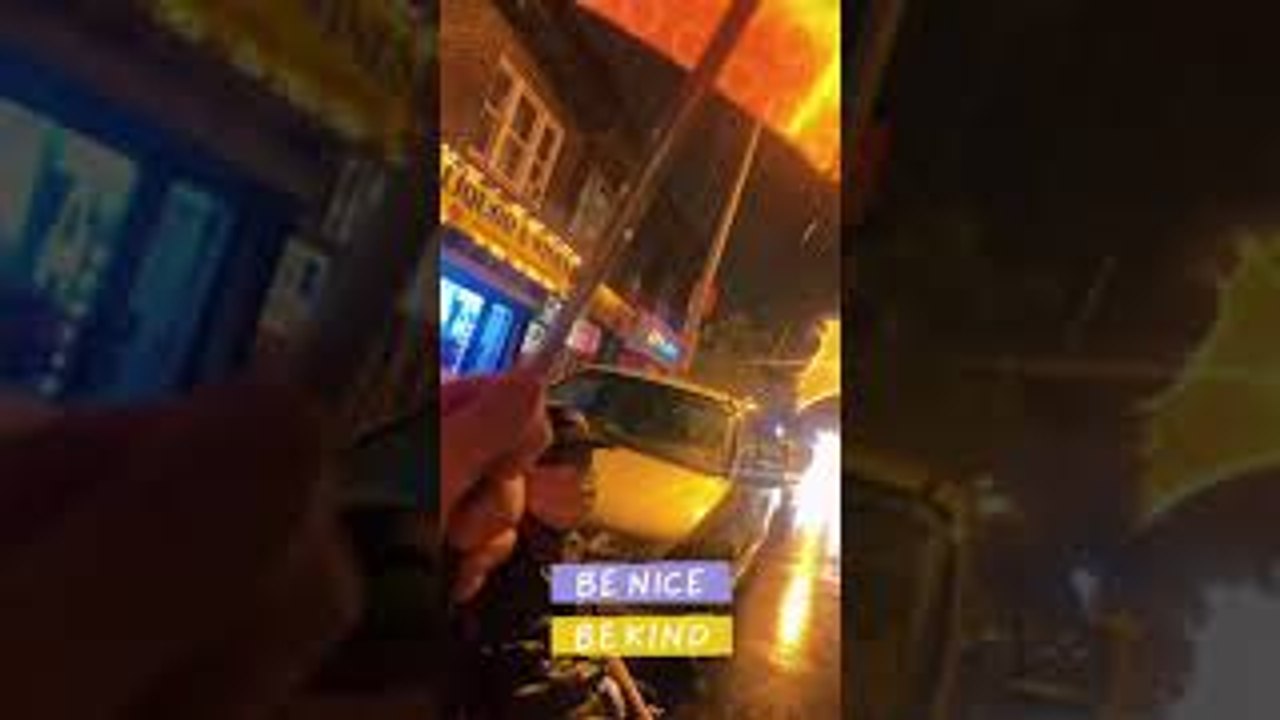 Woman Gives Umbrella to Man Waiting for Bus During Hurricane