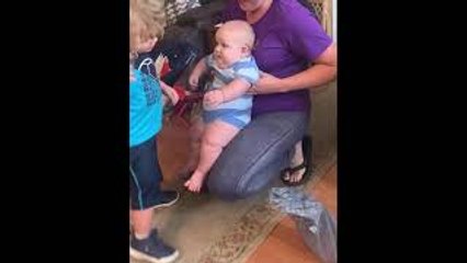 Toddler Tries to Hold Big Cousin Infant