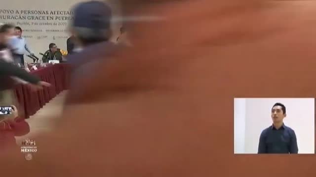 Un grupo de personas irrumpe con pancartas y gritos en un acto del presidente de México