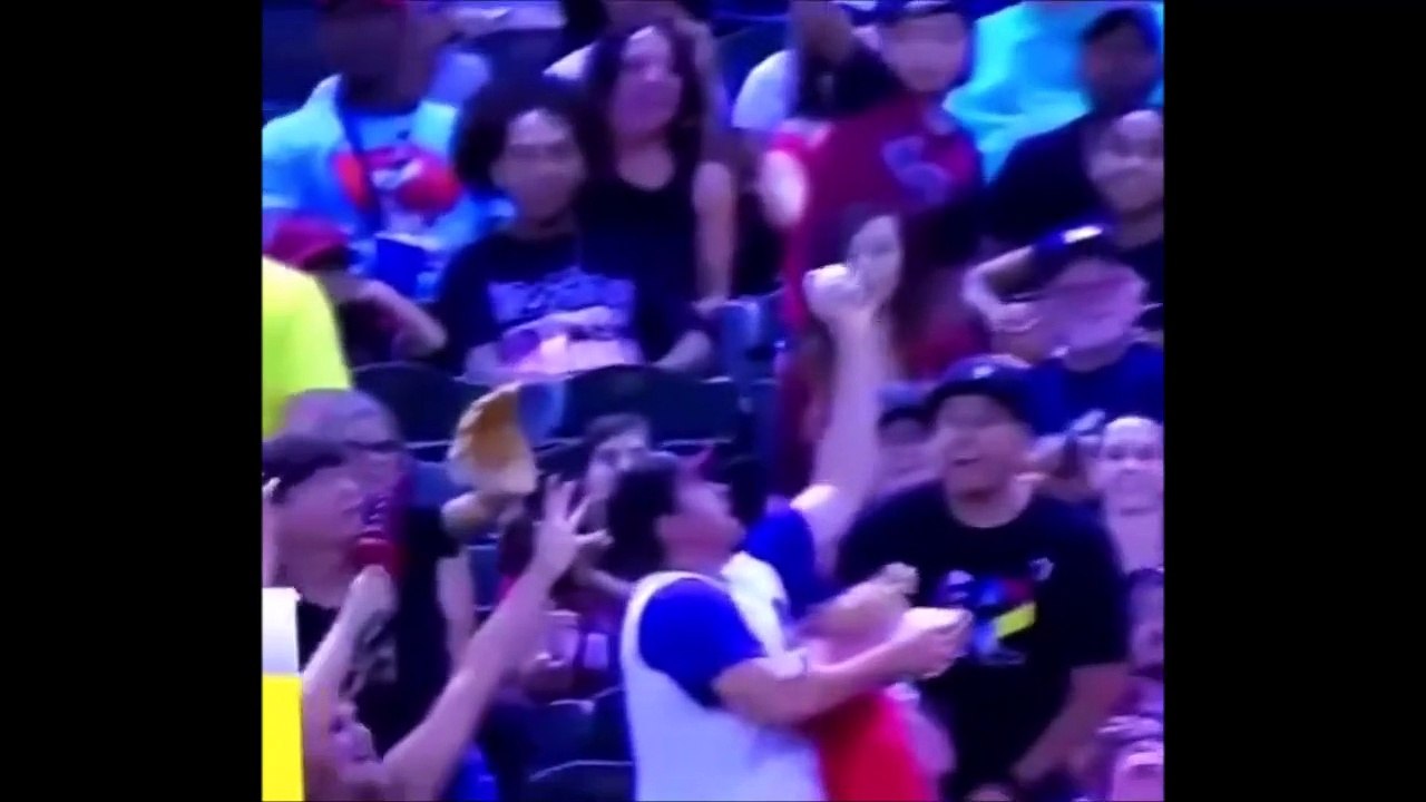 Une bière dans la main droite, son bébé dans la gauche... il réussit à attraper la balle de baseball.