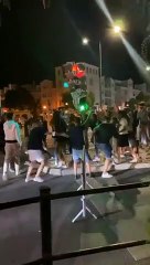 Une fille se prend un feu tricolore dans la tête pendant une fête dans la rue