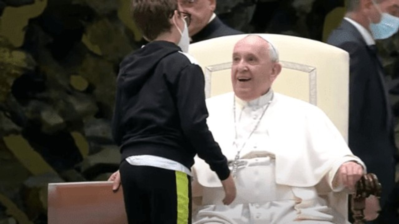 Un jeune enfant handicapé monte aux côtés du pape au début de l'audience