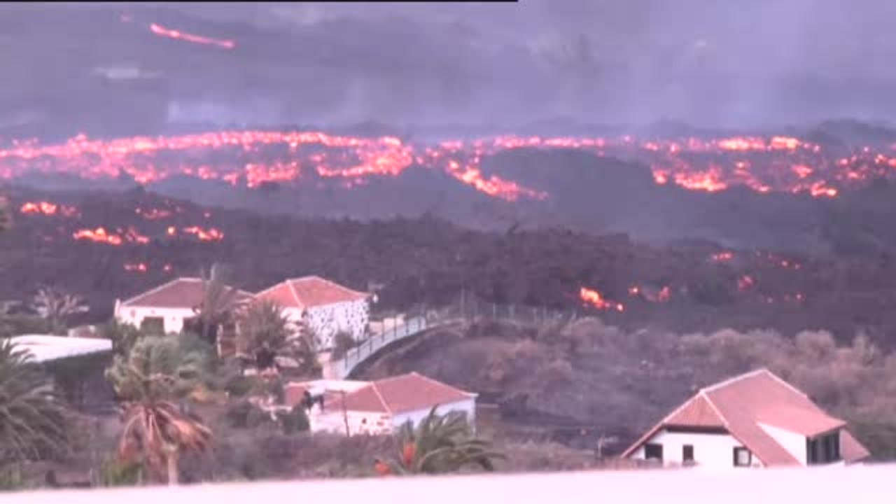 Vecinos desalojados observan su casa a punto de ser engullida