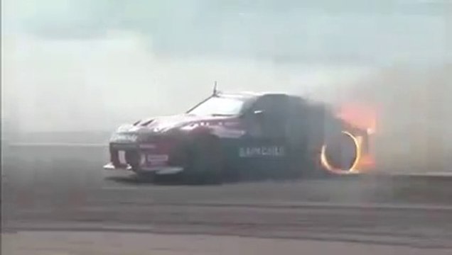 Une voiture de drift termine sa session avec les pneus en feu