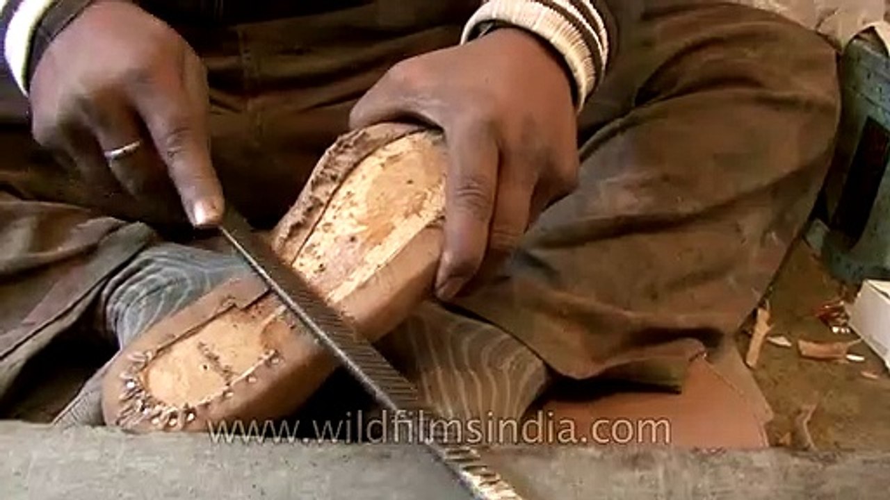 Cobbler making leather boots by hand