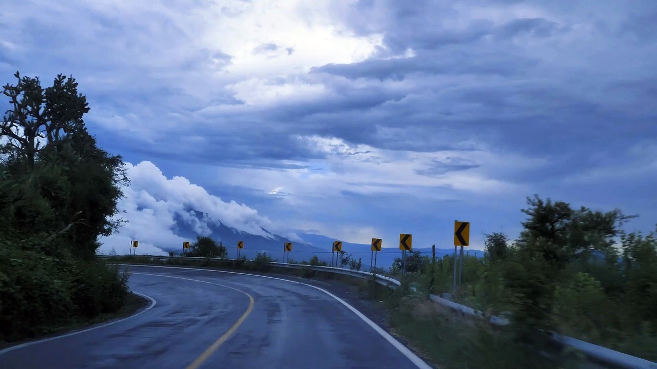 Going down a curved highway down a mountain,Lake surrounded by dry grass in the savanna