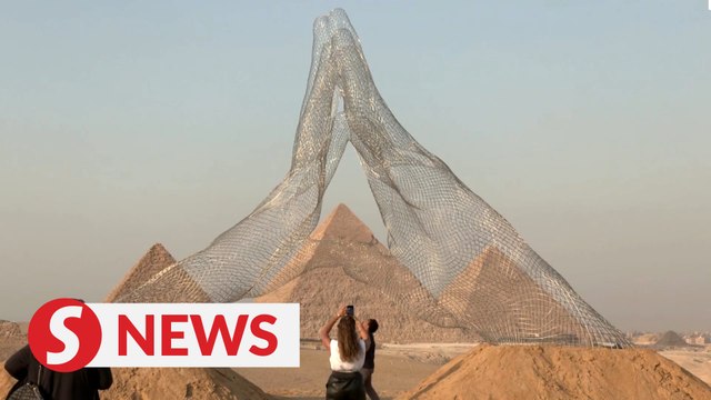 Larger-than-life sculptures by Giza pyramids