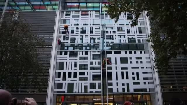 Activistas medioambientales protestan descolgando una pancarta en el Ministerio de Interior británico
