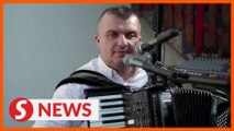 Bosnian musician sticks card reader on accordion