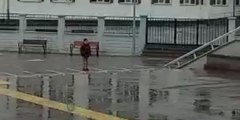 Okula geç kalan öğrenci, sirenleri duyunca sağanak yağmura aldırmadan saygı duruşuna geçti