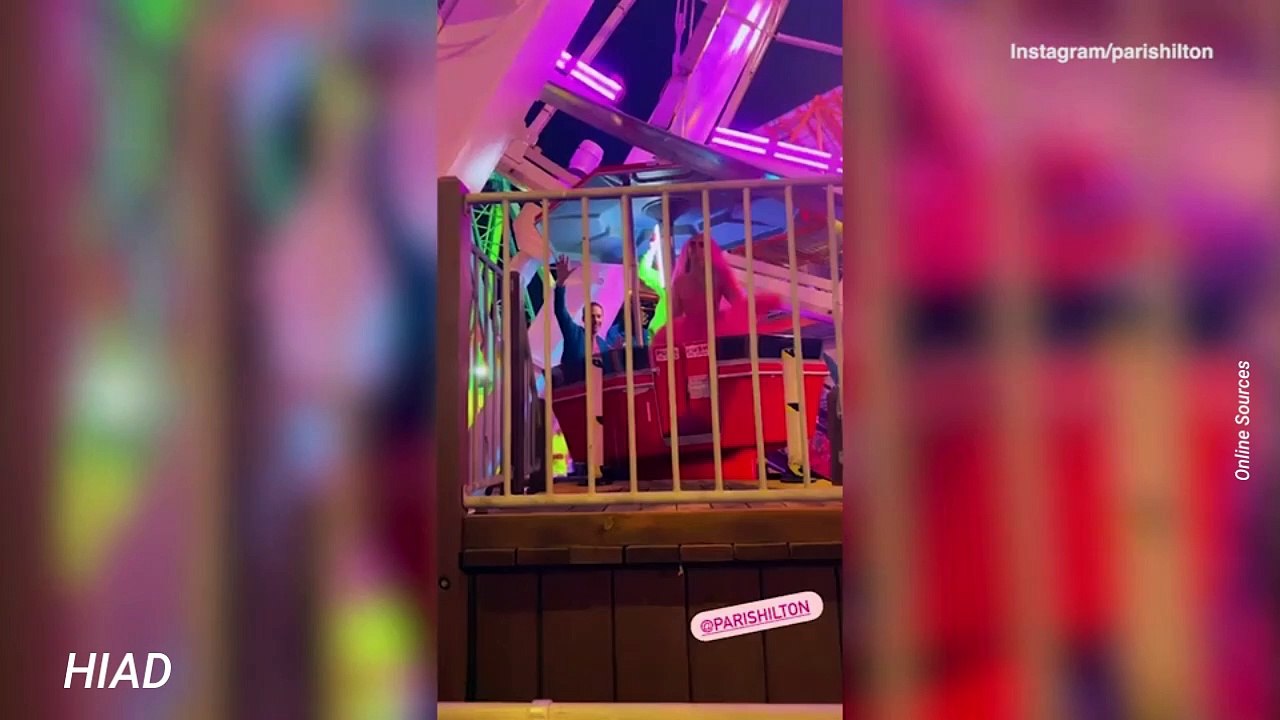 Bride Paris Hilton wows in neon pink as she and husband Carter Reum head to 'Paris World' carnival