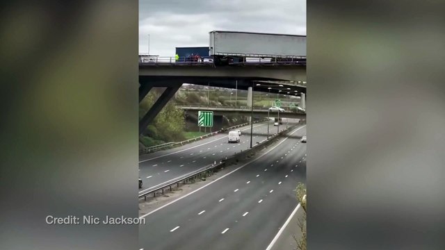 Dramatic dashcam footage has caught the moment a lorry almost fell off of the M25