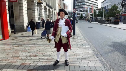 Town crier yells news of shop re-opening