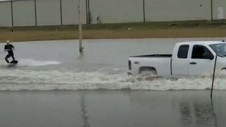 Man Surfs Flooded Parking Lot
