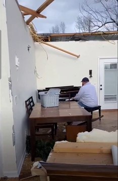 Un homme joue du piano dans une maison détruite par une tornade