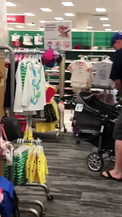 Man Struggles with Baby Stroller in Store