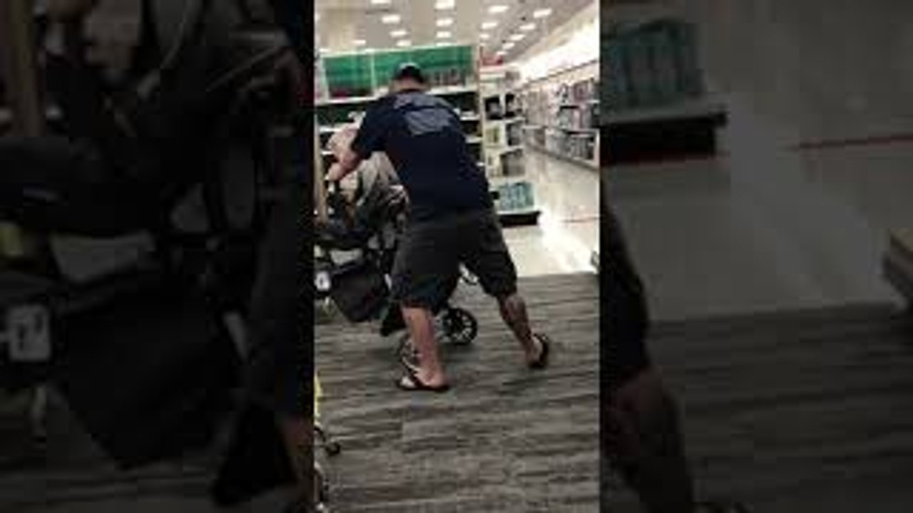 Man Struggles with Baby Stroller in Store