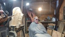 Man Carves Wooden Portrait of Legendary Carver With Chainsaw in Front of Him