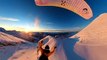 Paraglider Flies and Skis Over Golden Hour Mountains