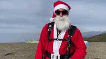 Yamaç paraşütüyle Amanoslardan atlayıp Noel baba kostümüyle hediye dağıttı