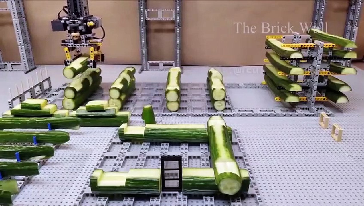 Un homme fait une maquette de maison avec des lego et des concombres
