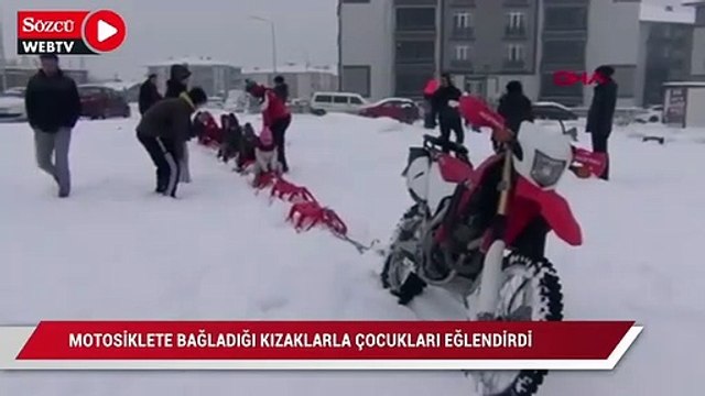 Motosiklete bağladığı kızaklarla çocukları eğlendirdi