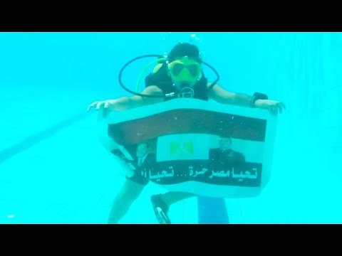 ابن الشهيد منسي يرفع علم مصر بصورة والده والرئيس بأعماق المتوسط