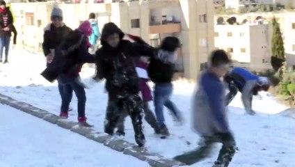 أطفال يستمتعون بالثلوج المتساقطة في دمشق