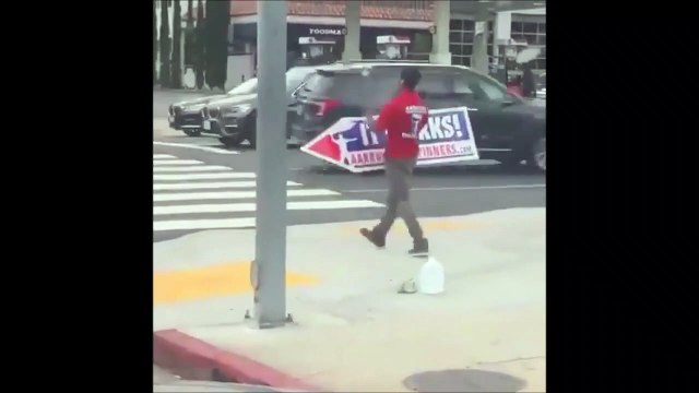 Il manie son panneau publicitaire comme un dieu