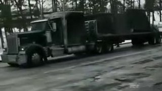 Un camion tente de monter une route verglacée mais n'y arrive pas