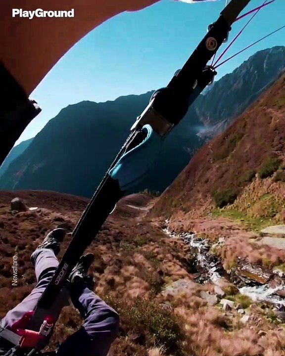 Un piloto de parapente vuela a ras del suelo en los Alpes austriacos