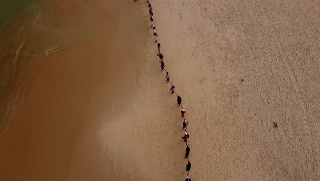 Hundreds gather on beach to 'hug' the ocean for World Oceans Day