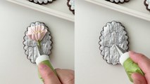 'Cookie artist pipes a pretty pink flower on a crackled base '