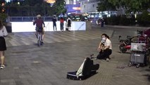 Guangzhou'da kafası üstünde durarak şarkı söyleyen sokak sanatçısı