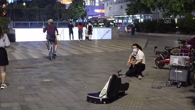 Guangzhou'da kafası üstünde durarak şarkı söyleyen sokak sanatçısı
