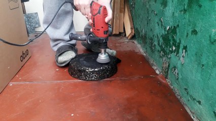 Grinding a frying pan from soot on the balcony