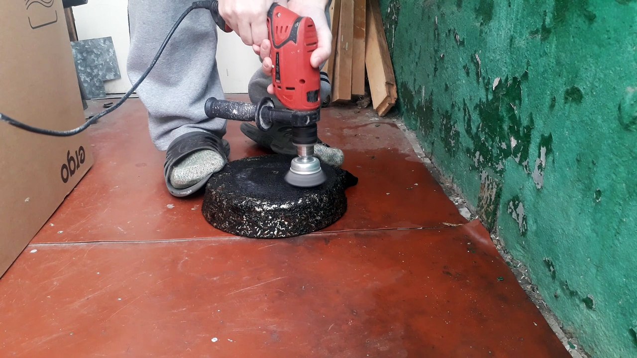 Grinding a frying pan from soot on the balcony