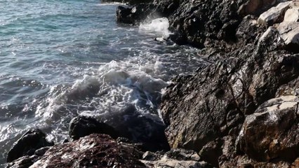 SEA WAVES CRASHING ON ROCKY SHORE