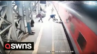 Railway police official rescues a man after he fell from a moving train