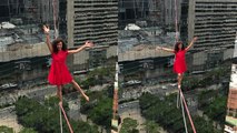 'Brazilian yoga trainer & athlete walks a highline above a São Paulo street '