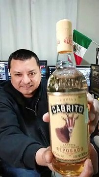 presentando una botella de tequila cabrito reposado exelente bebida tranquilizante relajante de jalisco mexico para el mundo