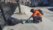 Ein Polizist fotografiert einen Jugendlichen, der den Fuß eines Obdachlosen hält und für ihn betet