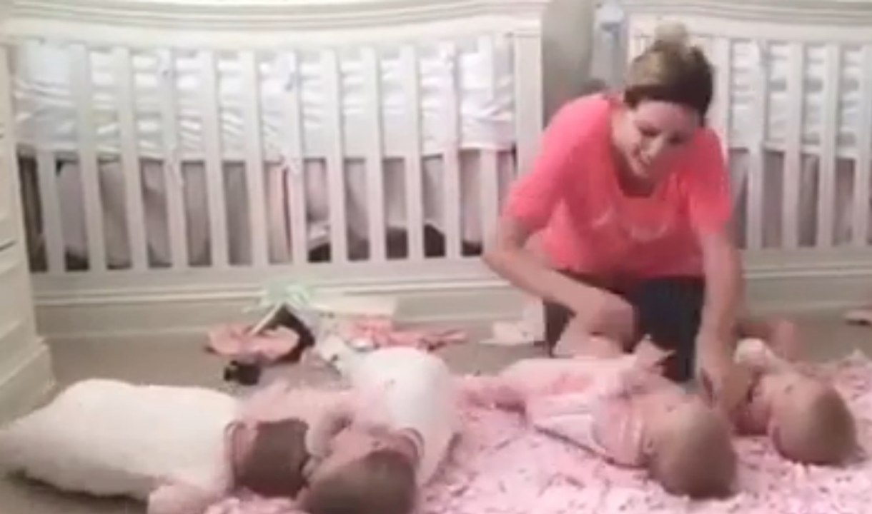 Diese junge Mutter wickelt ihre Vierlinge auf dem Boden... Eine tüchtige Mama!
